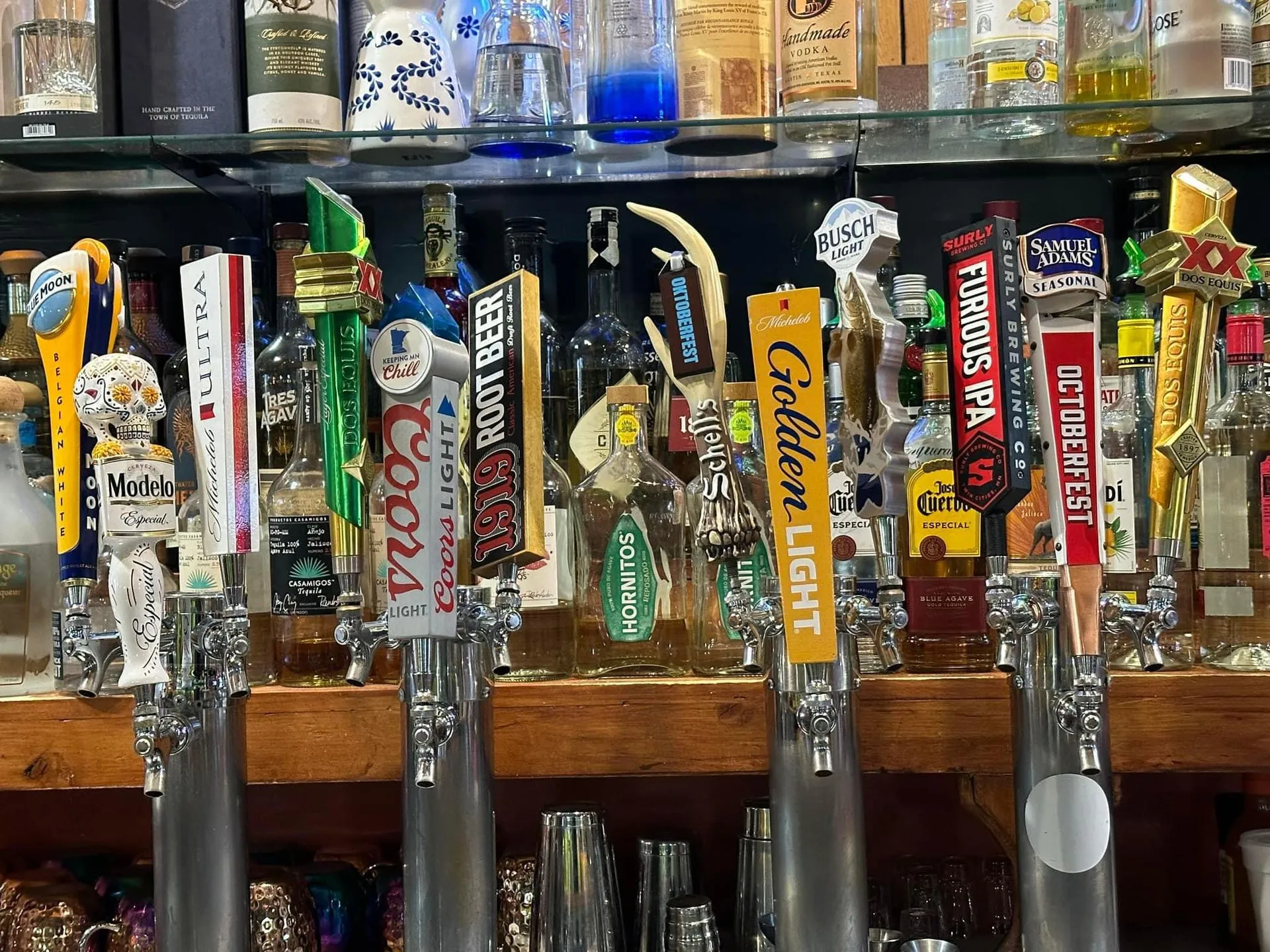 Warmly lit bar inside Mango's Mexican & American Grill with a row of beer taps